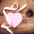 ;ink heart and ribbon sitting on a wooden block on top of a tree knot