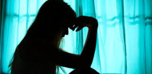 profile shadow of a woman holding her head in hand showing mental health issue