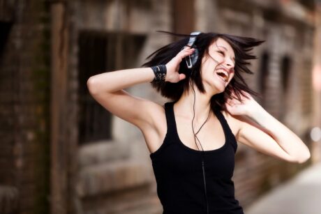 woman dancing with headphones smiling as she listens to her favorite music