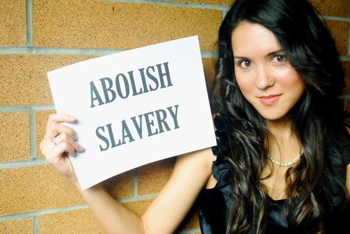 Tara Teng holding poster stating abolish slavery