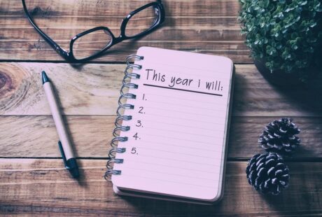 glasses, pen and notebook with text reading this year i will