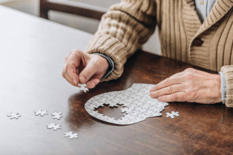 senior working on puzzle missing pieces symbolizing memory issues of alzheimers disease