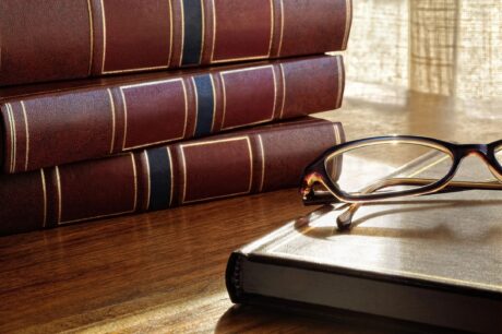 law books on desk with a pair of eye glasses 