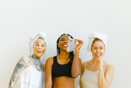 three young women wearing head spa towels and wiping face having fun 