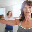 two women in gym stretching