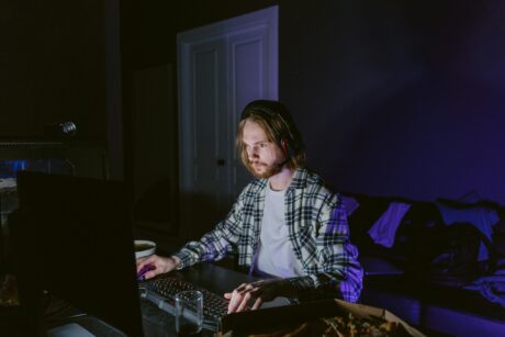 young male playing online casino at desk on a computer