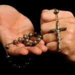 two hands holding a rosary